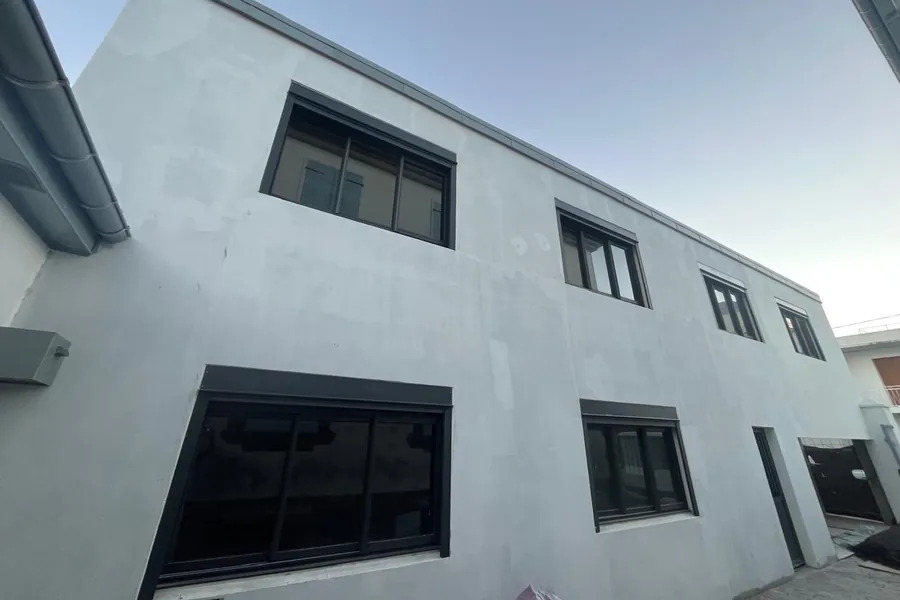 Fenêtres coulissantes aluminium anthracite sur une façade neuve