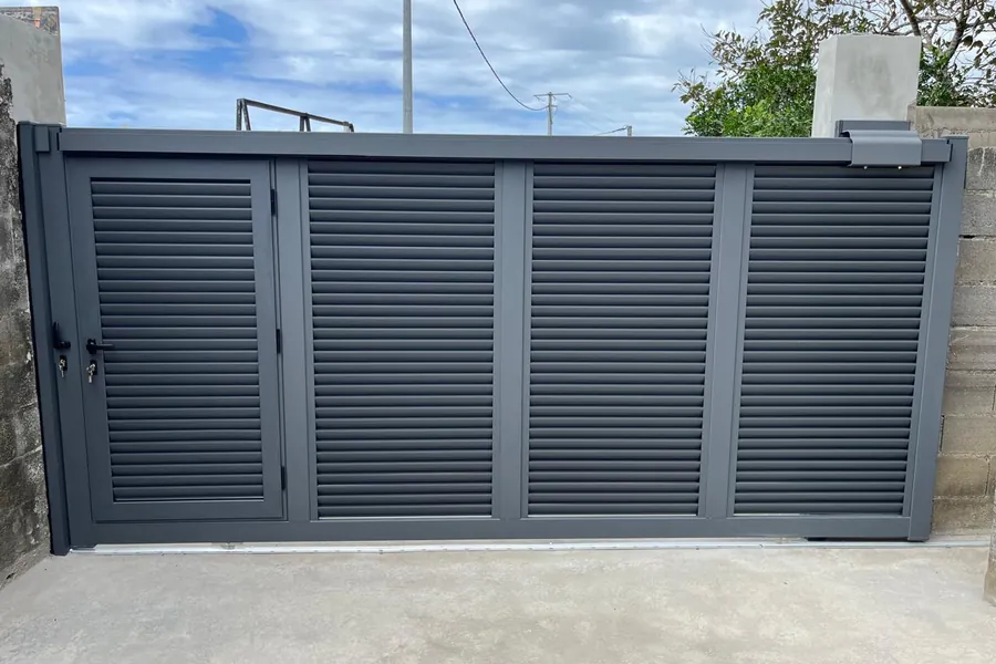Portail coulissant aluminium anthracite à persiennes avec portillon intégré